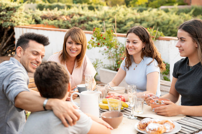 Petit-déjeuner convivial en terrasse l'été, moment de partage en famille au soleil