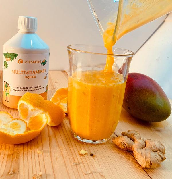 Smoothie Mon Soleil versé dans un verre, avec le flacon de Multivitamines Liquide Vitamoon, une orange, une mangue et du gingembre