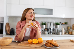 Table en bois clair avec un verre de boisson vitaminée à la lumière du matin, symbolisant le rituel bien-être Vitamoon pour préparer le corps à l’hiver.