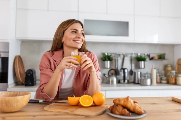 Table en bois clair avec un verre de boisson vitaminée à la lumière du matin, symbolisant le rituel bien-être Vitamoon pour préparer le corps à l’hiver.