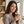 Femme souriante tenant un verre de Collagen Choco Latte dans un intérieur chaleureux. Dégustation de la boisson au collagène et au chocolat au quotidien.