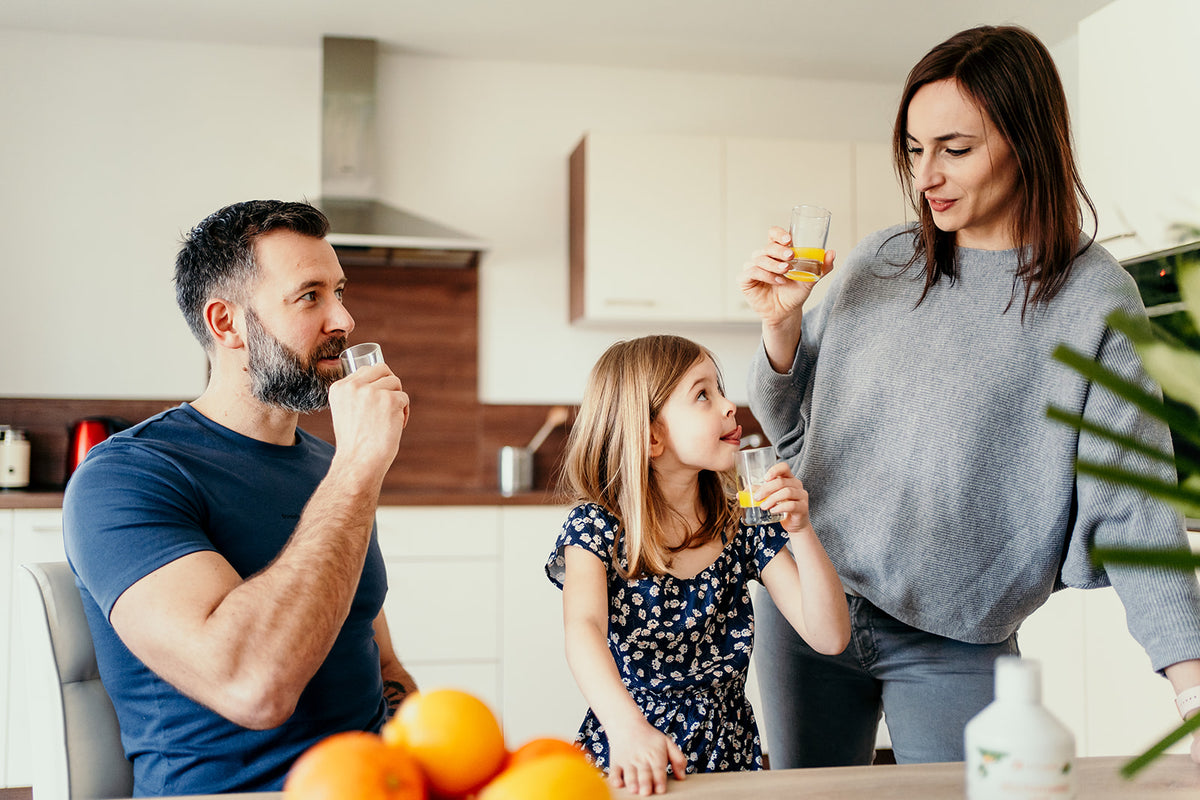 Famille dans sa cuisine buvant un petit verre de Multivitamines Liquide Vitamoon