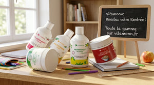 Gamme de compléments alimentaires Vitamoon pour la rentrée : collagène marin liquide, multivitamines, probiotiques et collagène latte sur un bureau d'écolier avec ardoise